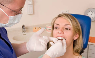 Dentist placing woman’s Invisalign tray