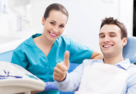 Man in dental chair giving thumbs up