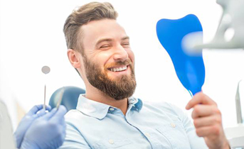 Man looking at smile in mirror