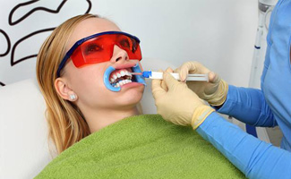 Woman receiving teeth whitening treatment