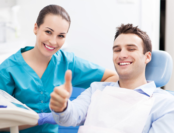 Man in dental chair giving thumbs up