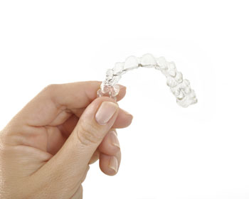 Gainesville dental patient holding Invisalign clear aligners