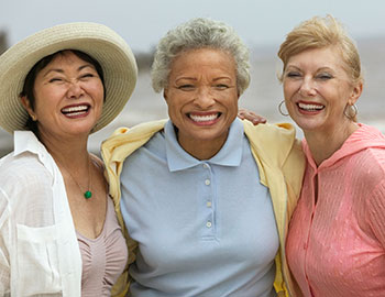 Group of three older women with dental bridges smiling