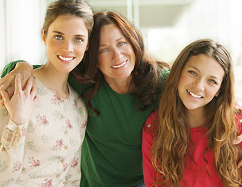 3 women smiling after receiving braces at Dr. Bassiri's Gainesville dental practice